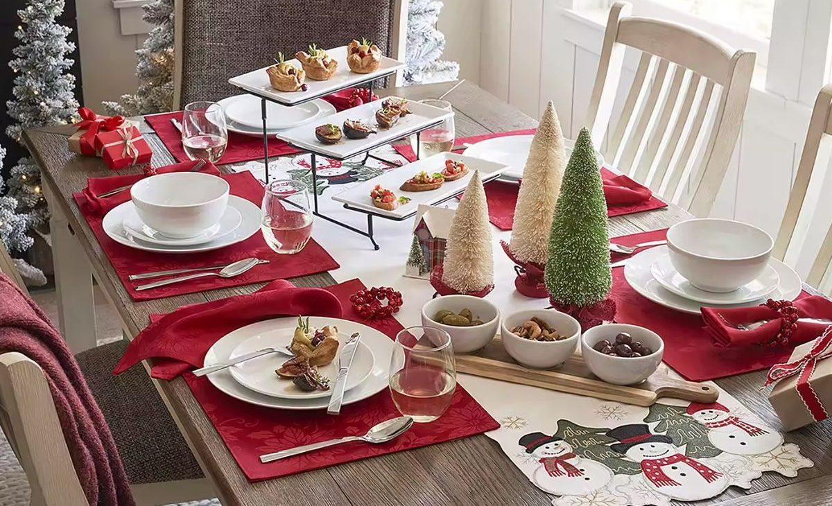 dining room table set with Christmas linens and dinner plates and decor