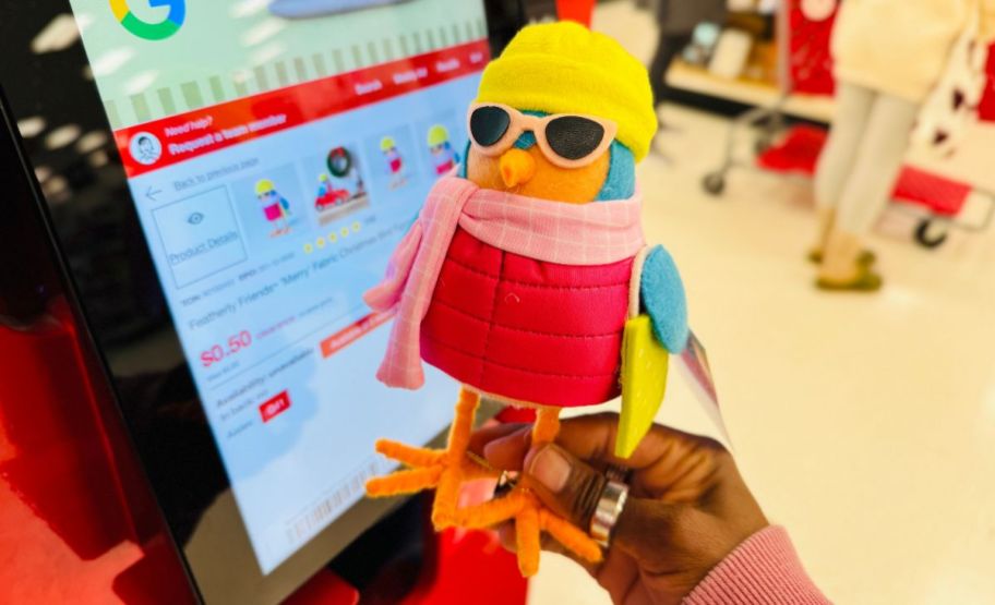 a womans hand holding a felt bird friend next to a product scanner