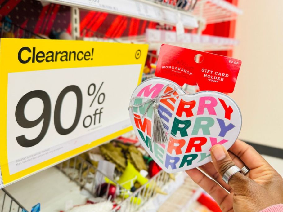 a woman holding a gift card tin up to a pricing scanner