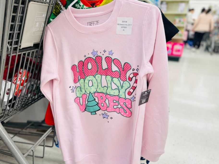 Hobby Lobby Holiday Sweatshirt hanging from a cart