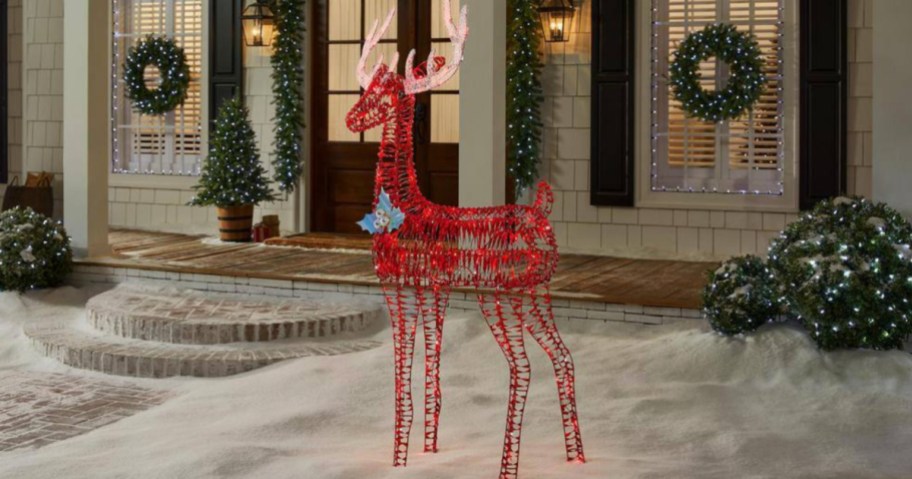 Red metal reindeer with lights outside home