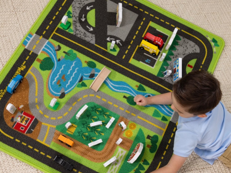 boy playing with wooden toys on rug